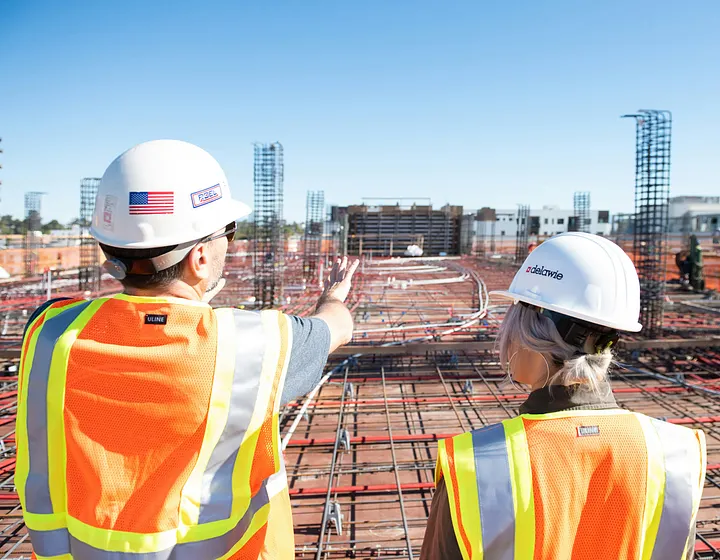 Man and woman standing and talking by a construction site