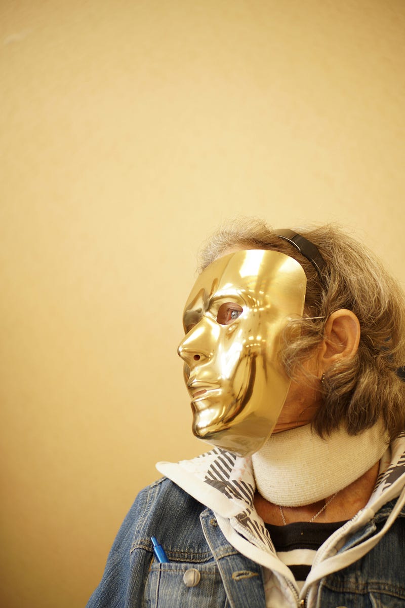 Older woman wearing a golden mask