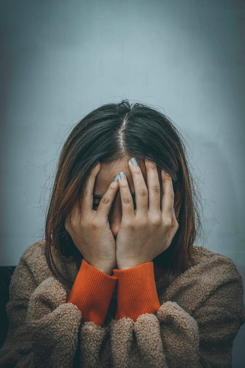 Teenager covering her face while crying